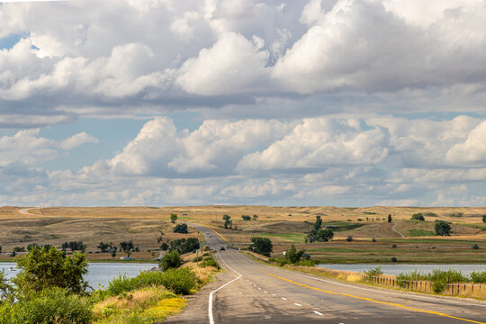 Vast View of Saskatchewan Landing Bridge Crossing with Surrounding Prairie Land Under a Large Cumulus Clouds