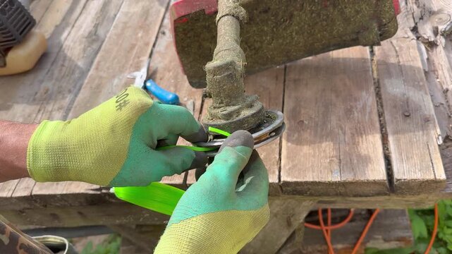 Person repairing a petrol brush cutter trimmer head outdoors, lawn care, yard maintenance, tools, equipment service, gardening