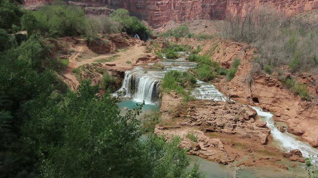 Havasu Creek cascades surrounded by canyon walls and greenery