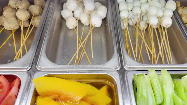 Assorted Wok Ingredients on Display in Asian Restaurant &ndash; Fresh Mushrooms, Greens, Sliced Vegetables, Various Noodles, Glass Noodles, Meatballs, Shrimp and Chicken for Custom Stir-Fry