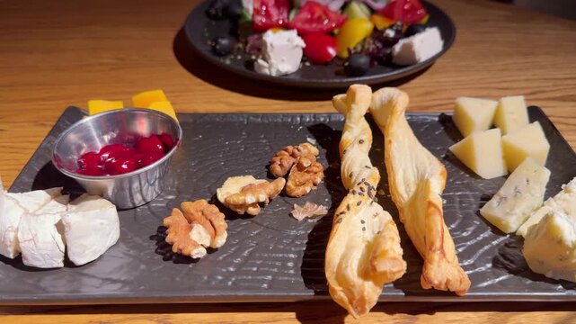 Cheese Platter with Roquefort, Brie and Walnuts on Restaurant Table &ndash; Assorted Cheese Board Served for Appetizer or Dessert
