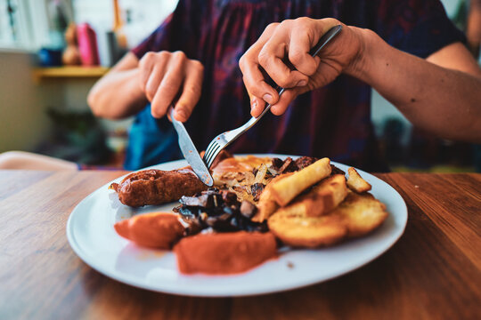 Eating a Full English Breakfast With a Knife and Fork at a Table