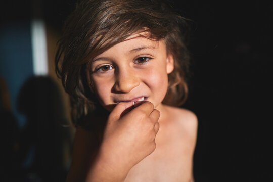 Boy Touching a Loose Tooth With His Hand