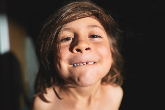 Boy Grinning and Showing His Teeth in an Indoor Portrait