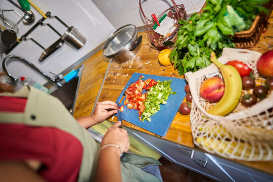 Person chopping fresh vegetables on kitchen counter