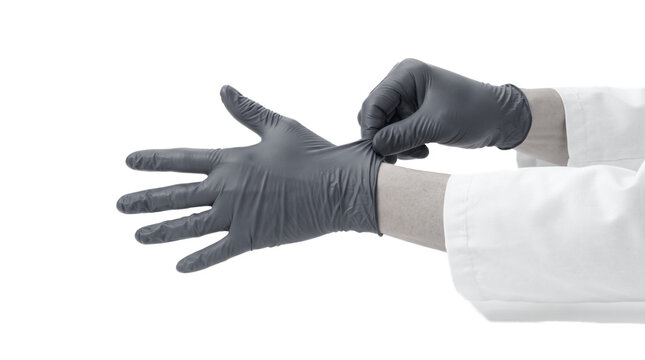 Doctor or scientist wearing white lab coat putting on dark gray latex or nitrile protective gloves