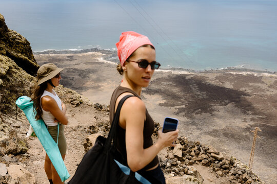 Fitness friends admiring the Lanzarote coastline views from a cliff.