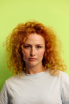 Woman faces the camera in front of a green background