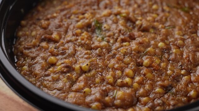 Freshly Cooked Healthy Millet Khichdi Served Hot in a Black Bowl, Close-Up Food Shot.