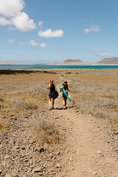 Female friends strolling on a desert on Lanzarote's coast