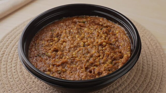 Freshly Cooked Healthy Millet Khichdi Served Hot in a Black Bowl, Close-Up Food Shot.