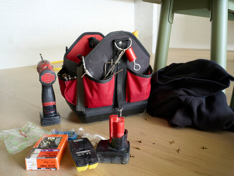 Tools and a Bag on a Wooden Floor in a Home Setting