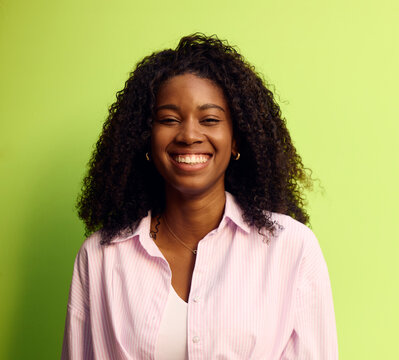 Woman smiling in front of a green background