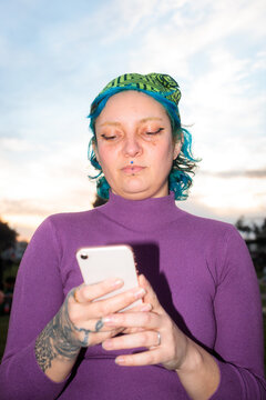 Woman looking at phone outdoors in direct flash
