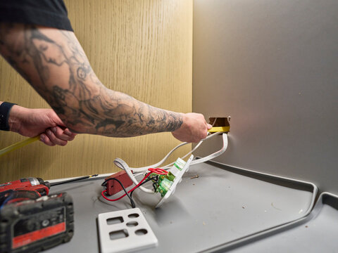 Electrician Feeds Cable Through Cavity Wall