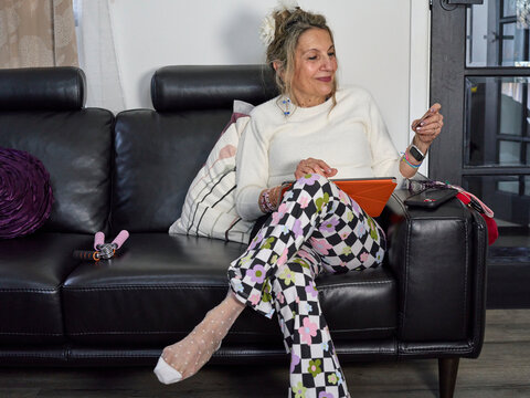 Happy Senior on a Couch Using an iPad & Shopping Online