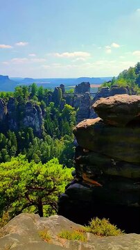 View over monumental Bastei sandstone pillars and ancient bridge near Kurort Rathen village in the national park Saxon Switzerland by Dresden, Saxony, Germany.
