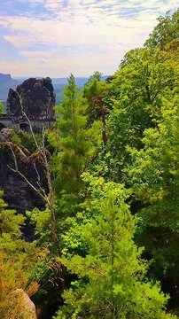 View over monumental Bastei sandstone pillars and ancient bridge near Kurort Rathen village in the national park Saxon Switzerland by Dresden, Saxony, Germany.