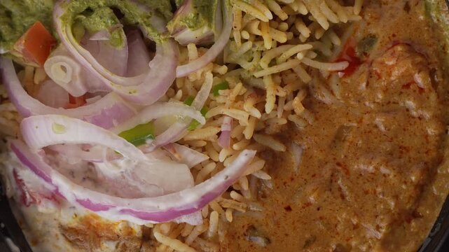 Aromatic Spiced Masala Rice Served with Rich Indian Curry and Fresh Sliced Onion Topping in a Bowl, Close-Up Food Shot.