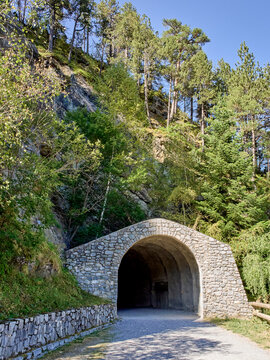 Tunnel excavated in the mountain rock in Cam&iacute; de les Pardines, hiking trail in Encamp. Andorra, Europe