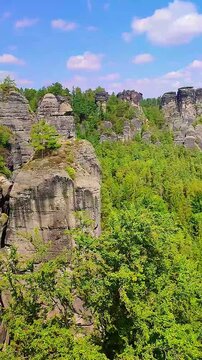 View over monumental Bastei sandstone pillars and ancient bridge near Kurort Rathen village in the national park Saxon Switzerland by Dresden, Saxony, Germany.