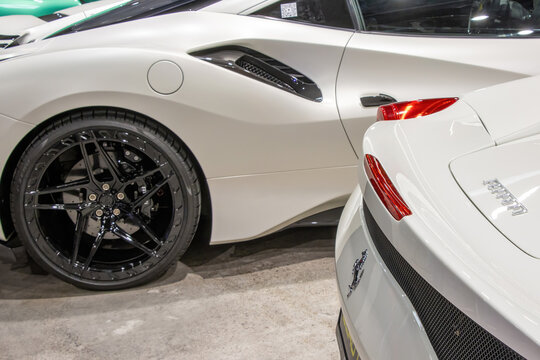 Close-up of white Ferrari sports cars on display at the Warsaw Motor Show.