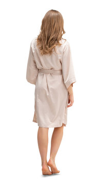 Woman in a silky bathrobe walking seen from behind, isolated on white and transparent background