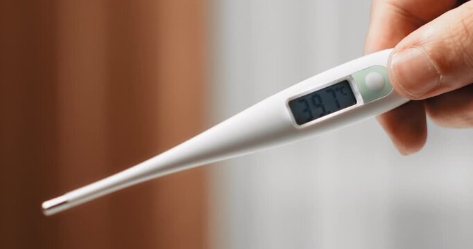 Digital thermometer showing high fever of 39.7 degrees Celsius