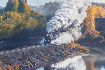 Retro steam train moves along the lake.  © serjiob74