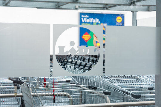 Berlin, Germany - 16 August 2026. Rows of shopping carts are parked at a Lidl trolley bay outside the store. Retail, shopping, consumerism, convenience, commerce, organization, branding.