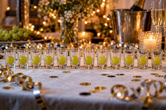Shot glasses with one grape each on a New Year's Eve party table