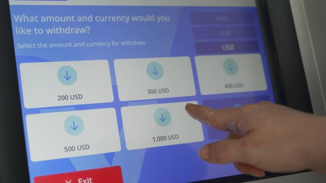 Customer selects US dollars and withdrawal amount on an ATM screen. Hand uses cash machine touch display. Banking, money withdrawal, transaction and financial service concept