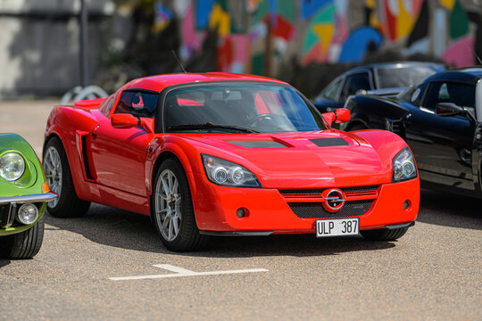 Trollh&auml;ttan, Sweden - August 22 2026: Red Opel Speedster sports car displayed among enthusiast vehicles outdoors.