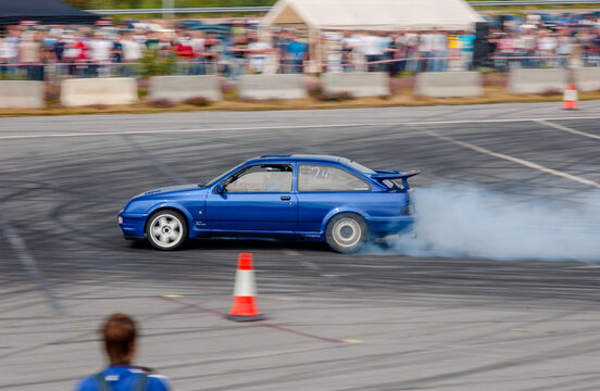 Kristiansand, Norway - August 20 2005: Blue Ford Sierra performance car drifting with dense smoke.