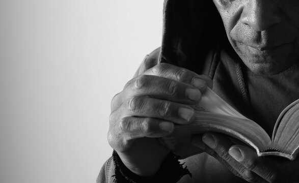 praying to god with hands showing his religious faith with God Caribbean man praying with background with people stock photo stock image