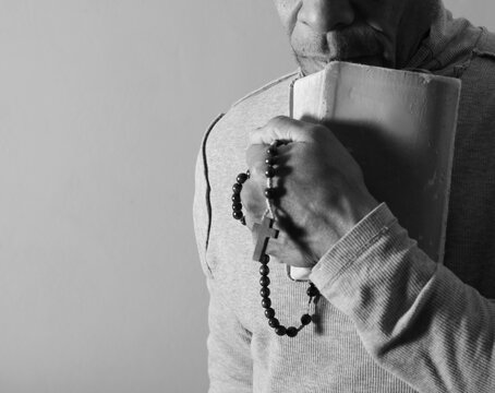 praying to god with hands showing his religious faith with God Caribbean man praying with background with people stock photo stock image