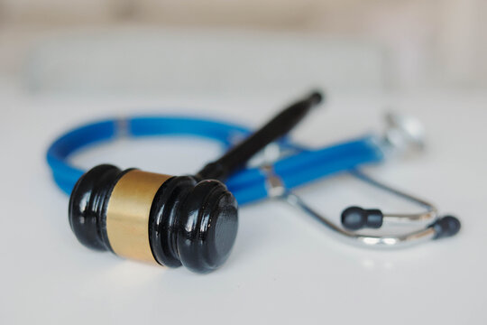 Judge's gavel and stethoscope on a white background, symbolizing medical law, healthcare regulations, professional ethics, malpractice litigation, and patient rights.