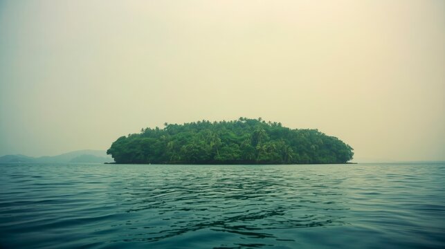 Distant island rises from calm, deep blue waters