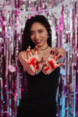 Woman at a Halloween party with bloodied hands. © Marco