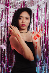 Woman showing her bloodied hands at a Halloween party. © Marco