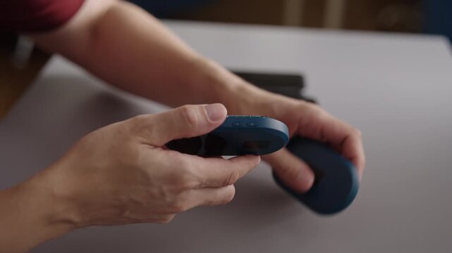 Close-up hands of unrecognizable person unboxing new portable wi fi router, unboxing concept for wireless internet connection and mobile hotspot gadget. Shooting in slow motion.