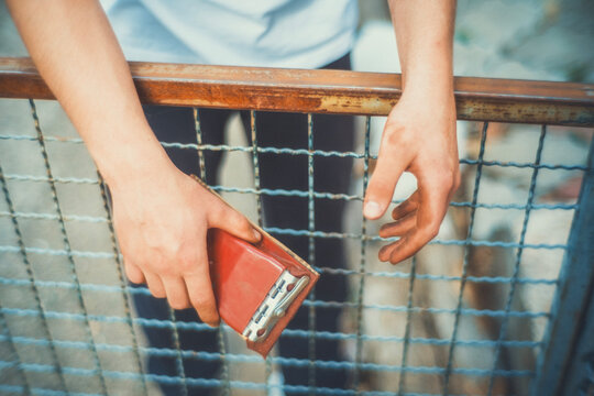Close-up of hands using a sanding block to smooth a rusty metal fence before painting. Motion blur adds a raw, authentic feel. DIY restoration photo for craft and renovation projects