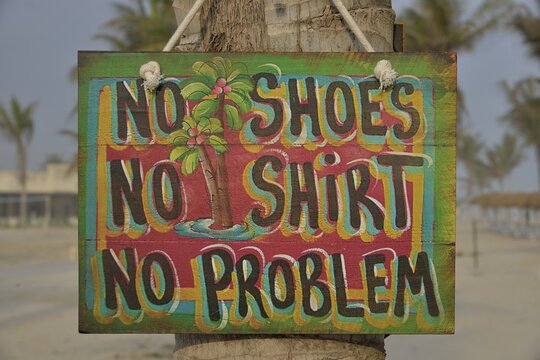 Sign "No shoes, no shirt, no problem" on the beach of Salalah Rotana Resort, Salalah, Dhofar Region, Oman
