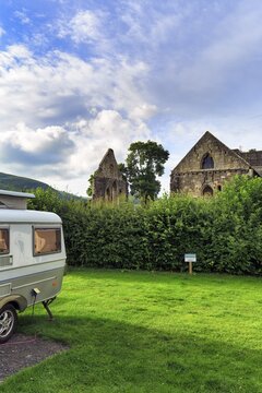 Caravan with retractable roof in a meadow, retro, cult, ruin, campsite, Abbey Farm, Llangollen, North Wales, Wales, Great Britain