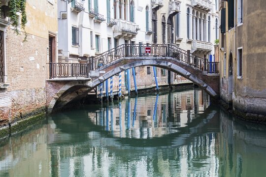 Bridge with reflection in canal, Venice, Veneto, Italy
