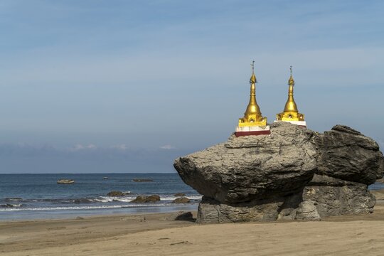 Golden pagodas on rocks at the beach, Ngwe Saung, Myanmar