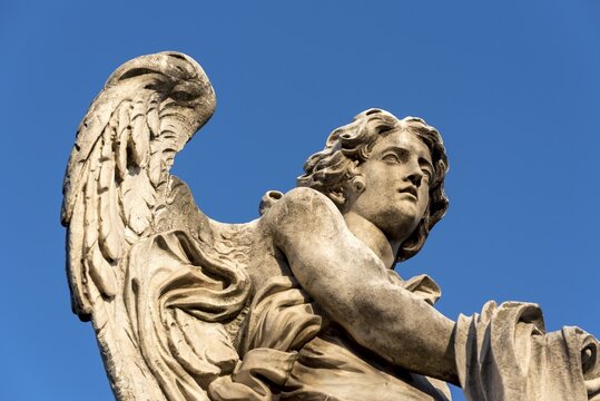 Statue of angel with garment and dice, Ponte Sant'Angelo bridge, Rome, Italy