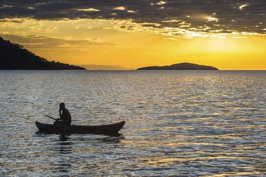 Man in a little fishing boat at sunset, Lake Malawi, Cape Maclear, Malawi