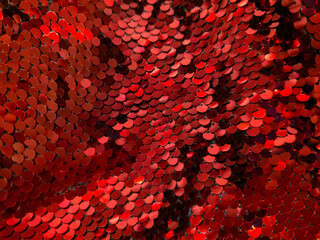 Red sequins close up, shimmering round discs layered like fish scales with highlights, festive Christmas and New Year background. Holiday glitter concept, grainy film texture, high quality photo © Татьяна Швец