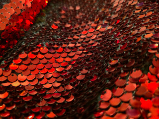 Red sequins close up, shimmering round discs layered like fish scales with highlights, festive Christmas and New Year background. Holiday glitter concept, grainy film texture, high quality photo © Татьяна Швец